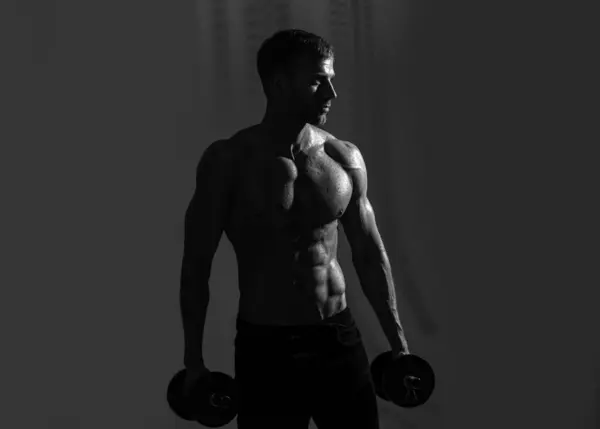 瘦小的躯干 男人与哑铃 肌肉发达强壮的人在锻炼 运动员做举重运动 健身和交叉配型 — 图库照片