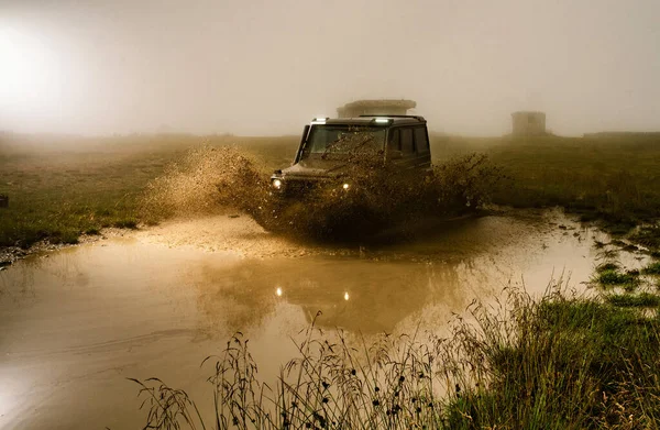 Mud and water splash in off-road racing. Off road car. Beautiful nature. Truck car wheel on offroad steppe adventure trail