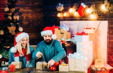 Ev Noel atmosferi. Yeni yıl konsepti. Evde Noel ağacı var. Aile mutluluğu konsepti. Mutlu Noeller ve mutlu yıllar. Noel süslemeleri ve tahta arka planda hediye kutusu