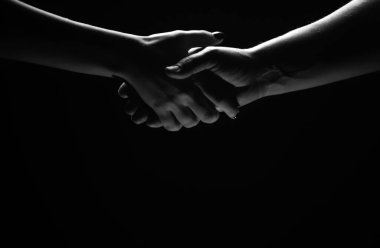İki ortak arasında tokalaşma. Kurtarmak ya da el hareketlerine yardım etmek. Kurtuluş kavramı. Kurtarma sırasında iki kişinin elleri, anlaşma, yardım. Siyah arkaplanda izole