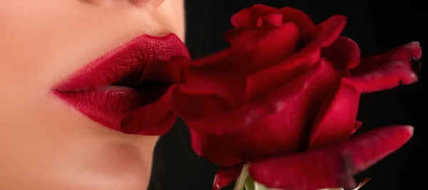 Sexy plump lips. Lips with red lipstick closeup. Beautiful woman lips with red rose