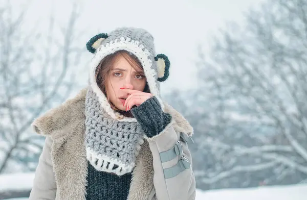 Sick in winter. Cold flu winter season, runny nose. Showing sick woman sneezing at winter park. Young woman blowing nose at snow winter background