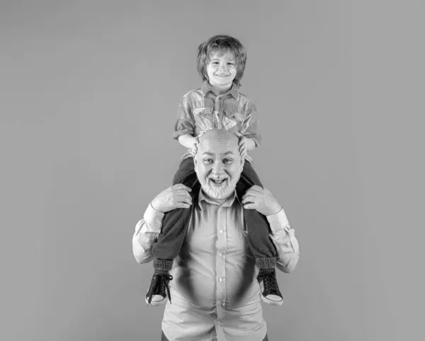 年轻的孙子和老祖父的背脊背 滑稽的脸孤立在蓝色的工作室 爷爷和可爱的男孩与滑稽的脸 — 图库照片