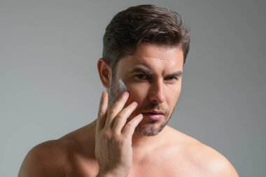 Cilt bakımı. Güzellik uzmanı yüz kremi sürüyor. Erkek spa modeli yüz kremi. Yüz kremi, nemlendirici, besleyici krem kaldırma. Yüz kremi cilt bakımı için. Kırışık kozmetik yüz tedavisi