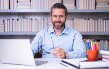 Öğretmenler günü. Öğretmenim okulda. Orta yaşlı öğretmenle bilgi ve eğitim. Kitaplı İspanyol öğretmen. Sınıfta ders veren adam. Üniversite sınavındaki öğretmen. Üniversite öğretmenleri