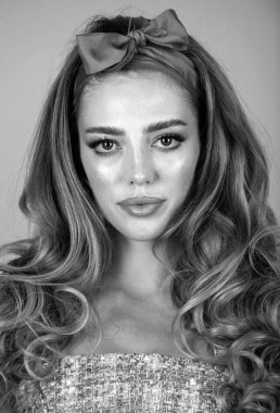 Pembe arka planda izole edilmiş güzel bir genç kadının portresi. Saçları yakın planda, şehvetli, güzel bir kadın model. Doğal güzellik kadını. Retro pin biçimi