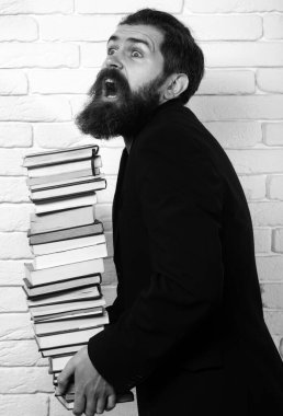 Funny teacher or professor with book stack. Thinking serious mature teacher. Falling books concept. Mature professor, middle aged teacher, bearded fun man. Books stacked fall