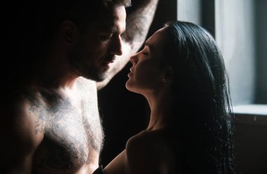 Sevimli seksi çift. Gömleksiz, kaslı bir adam öpüşen kız arkadaşını kucaklıyor. Birbirine aşık genç bir çift. Seksi, tutkulu çift kucaklaşması. Duygusal çift stüdyoda birlikte poz veriyor. Yakışıklı genç aşıklar.