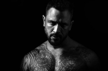 Acımasız bir adam, yakışıklı erkek modelin ciddi yüzü, erkek gücü kavramı ve güçlü. Ciddi yüzlü bir adamın yakın portresi.