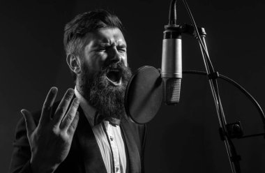Klasik müzik işte. Kayıt stüdyosundaki yakışıklı adam. Müzik performansı vokali. Şarkıcı mikrofonla şarkı söylüyor