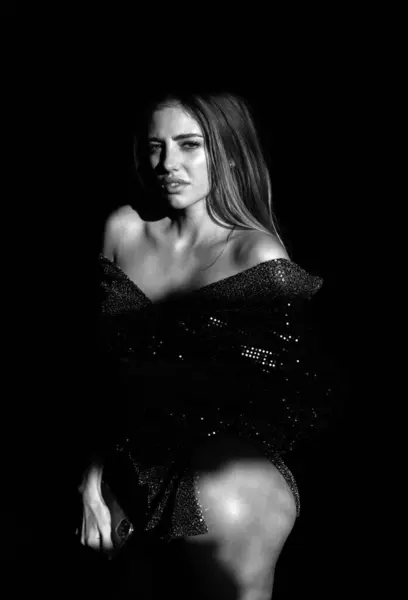 Sexy alluring woman, sensual young model looking seduce on black studio. Fashion portrait of elegant woman in vogue dress, glamor light