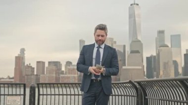 Takım elbiseli bir işadamı New York 'ta para sayıyor. Dışarıda parası olan bir iş adamı. Zengin iş adamı dolar sayıyor. Dolarlı heyecanlı iş adamı başarıyı kutluyor.