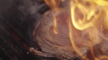 Ateşli ızgara et. Yanan ızgarada ızgara biftek pişiyor. Izgara et. Barbekü mermer bifteği ateşte. Barbeküde alevli biftek. Barbekü ve ızgara. Kızarmış et.