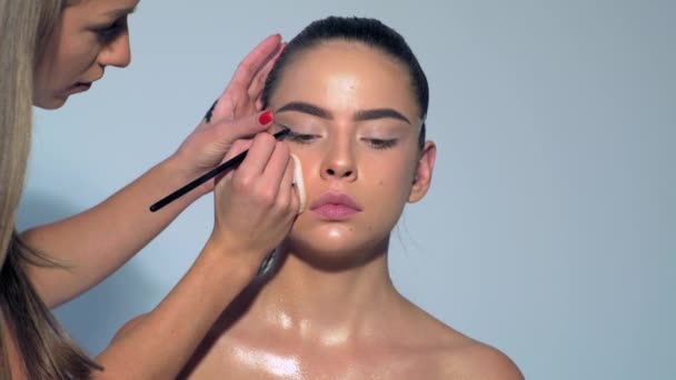 메이크업 아티스트는 화장품을 아름다움의 메이크업 마스터의 소녀의 입술에 그림을 그리는 — 비디오