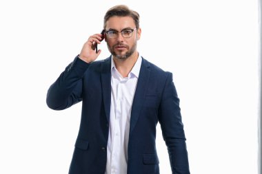 Takım elbiseli bir iş adamı telefonda konuşuyor. Promosyon mobil uygulaması. Stüdyonun arka planında izole edilmiş akıllı telefon kullanan sıradan giyinmiş bir iş adamı. Cep telefonu kullanan, sosyal medyayı karıştıran neşeli adamın portresi