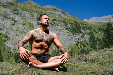 Özgürlük adamı meditasyonu. Doğada meditasyon. İspanyol adam yoga ve meditasyon yapıyor. Yaşam tarzı rahatlama konsepti, doğa üzerine meditasyon. Doğada sakinlik ve meditasyon. Lotus meditasyon yapıyor.