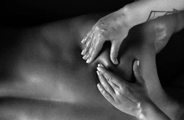 Masaj yapan kadının elleri, yakın plan. Fizyoterapist, omuzlarına ve boynuna masaj yapıyor. Fizyoterapist erkek sırt kaslarına masaj yapıyor.