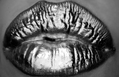 Makyaj malzemeleri ve makyaj malzemeleri. Altın ruj ve parlatıcı. Seksi ve şehvetli dudaklar. Altın dudaklar yakın çekim. Dudaklarda altın etkisi