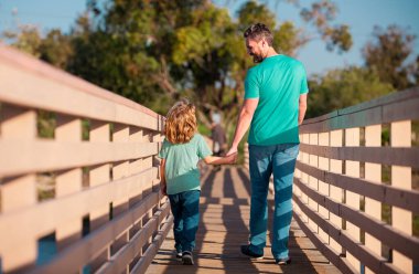 Mutlu oğul ellerini uzatıyor, baba. Arka manzara yakışıklı bir adam ve yakışıklı bir çocuk.