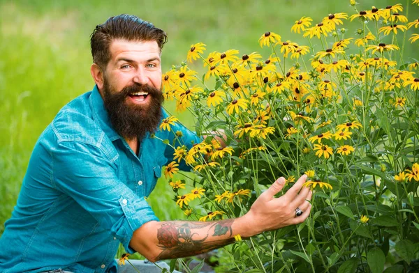 Spring summer mood. Bearded man with yellow flowers. Carefree and positive thinking. Rudbeckia flower