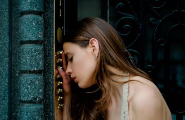 Kadın dahili iletişim düğmesi. Bayan elektronik kapı zili girişte. Genç elbiseli kız kapı klavyesine kod giriyor.