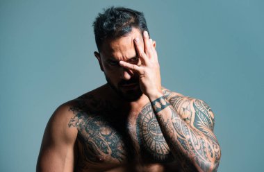 Adam yüzünü ellerle kaplamış ve üzgün ve korku ifadeleriyle jest yapıyor. Öfkeli çete adamı yaşam tarzı, ciddi yakışıklı adam yüzü örtülü.