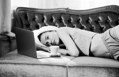 Uyandıktan sonra yatak odasında beyaz bornozlu ve havlulu kahve ve dizüstü bilgisayarı olan genç ve güzel kadınlar. Evde ya da otel odasında yatakta tasasız kadın modeller. Sabah serinliği