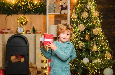 Noel hediyeli mutlu çocuk. Mutlu çocuk hediyeyle eğleniyor. Noel süsleri. Mutlu Noeller dilerim. Noel çocukları. Model çocuk hediyeyle eğleniyor.