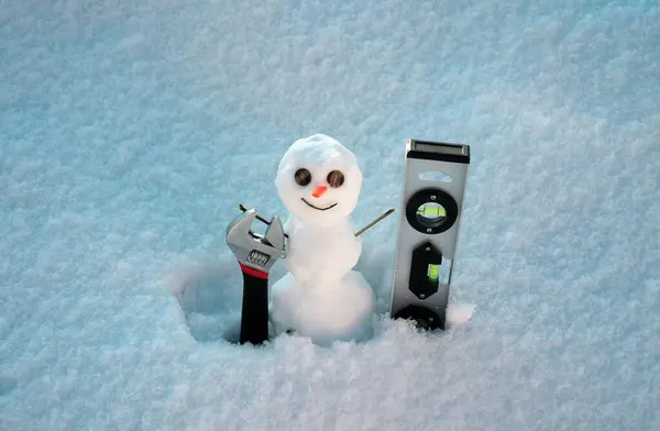 Snow man. Repairman with repair tools. Support repair and recover service. Snowman isolated on snow background