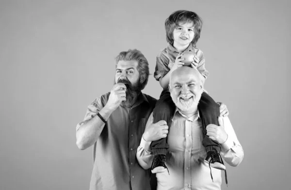 Grandfather father and grandson hugging and eating apple. Men in different ages