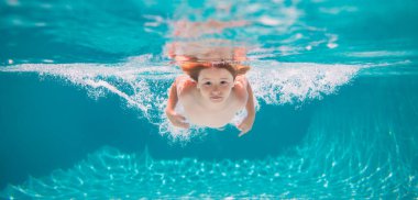 Young boy swim and dive underwater. Under water portrait in swim pool. Child boy diving into a swimming pool. Summer vacation concept