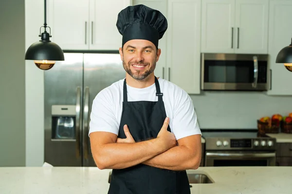 Cooking and culinary concept. Chef cook in uniform on kitchen. Male chef or cook baker man in apron cooking. Portrait of chef cook in beret. Cooking food concept
