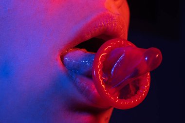 Kadın ağzında kullanıma hazır prezervatif. Doğum kontrol hapı. Prezervatif güvenli seks, enfeksiyonu önlemek için. Korunmak için prezervatif, seksi bir kadın dilinde prezervatif tutar. Güvenli seks. AIDS Günü. Doğum kontrol hapı.