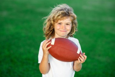 Açık hava çocukları spor aktiviteleri. Amerikan futbolu. Çocuk top atmaya hazır. Spor çocukları konsepti. Çocuklar için açık hava spor aktiviteleri