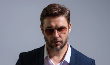 Gri stüdyodaki iş adamı izole edilmiş. Takım elbiseli zengin adam, stüdyo portresi. Başarılı bir iş adamı. Finansal başarı. İş adamı başarılı anlaşma