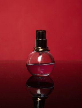 Parfüm şişesi kırmızıda. Aroma konsepti. Bir bardak parfüm. Parfümeri kozmetiği