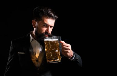 Sakallı ve bıyıklı hippi iş gününden sonra bira içer. Almanya Bavyera. Bira zamanı. Yakışıklı barmen elinde yarım litre bira tutuyor.