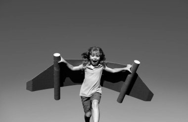 Sırt roketli süper kahraman çocuk. Yazın gökyüzü geçmişine karşı çocuk pilot. Kağıttan uçuşu olan çocuk, karton kanatlı oyuncak uçak, hayal gücü, çocuk özgürlüğü.