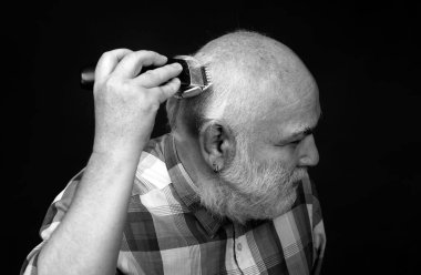 Orta yaşlı kel adam saç kesicisi, olgun kellik ve saç dökülmesi konsepti.