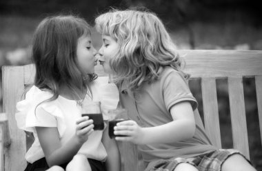 Yaz tarlasında güzel bir kız ve erkek portresi. Yaz parkındaki çocuklar. Şirin çocuklar yakın plan çekimde. Küçük sevimli bir çift erkek çocuk çayırda yürüyor. Çocuklar öpüşür ve sarılırlar. Korsanlı çocuklar