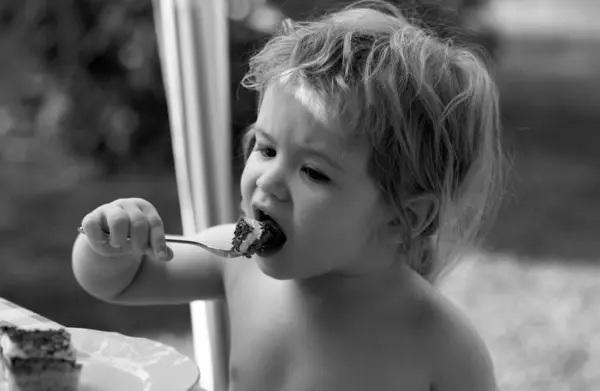 赤ん坊はケーキを食べる かわいい子は外でおいしい食べる — ストック写真