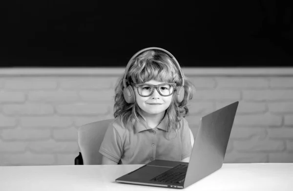 ヘッドフォンの勉強のオンラインの子供の男の子 イヤホンの子供はインターネットの網のレッスンを取る 学校での初日 — ストック写真