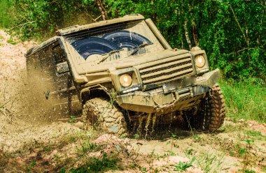 Ülke yol ve dağlar arka plan üzerinde büyük offroad araba tekerleği için alt görünümü. Büyük 4x4 araba ile seyahat konsepti. Off-road araç dağ yolunda gidiyor