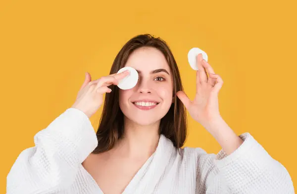 Woman taking off makeup with cotton wipe sponge. Beautiful girl model with natural makeup. Daily healthy beauty routine