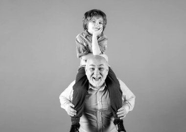 Torunum ve büyükbabam komik yüzlü, stüdyoda izole edilmiş. Dedem ve komik suratlı tatlı çocuk. Yaşlı bir akraba ve çocuk.