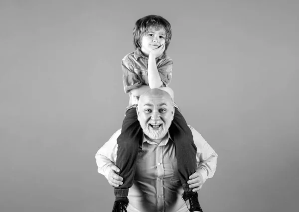 孙子孙女和祖父带着滑稽的脸坐在蓝色的工作室里 爷爷和可爱的男孩与滑稽的脸 有子女的老年亲属 — 图库照片