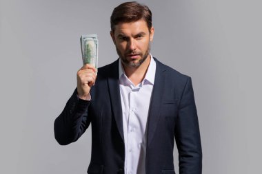 Paralı bir adam. Dolar banknotları. Elinde bir deste para tutan adamın portresi. Dolar, kredi, internet bankacılığı. Dolar banknotları, banka kredisi, mali tasarrufu olan zengin bir adam.