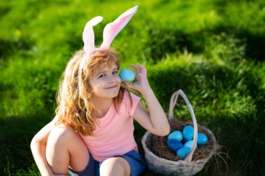 Paskalya yumurtası avlayan çocuk. Paskalya yumurtası ve tavşan kulaklı çocuk..