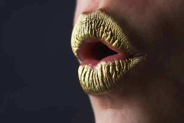 Sexy gold lips, golden lipgloss on sexy lips, metallic mouth. Sensual woman mouth. Sexy girl golden lips, gold mouth. Glowing gold skin and gild lips. Surprised mouth