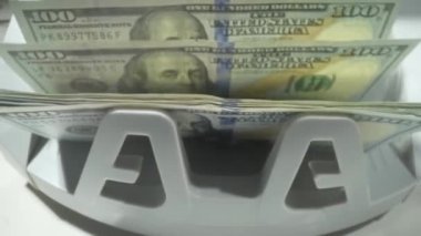 Para sayma makinesini kapat ve dolarları say. Banknot sayacı. Dolar banknotları olan para sayacı. Para sayma makinesi 100 dolarlık banknotları sayıyor.
